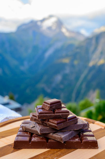 istock Handmade pure dark swiss chocolate and Alpine mountains on background 1282487414