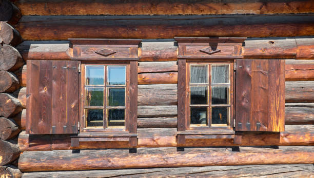 ログハウスの壁にオープンシャッターを持つ2つの木製の窓。古代の木造建築 - door open house facade ストックフォトと画像