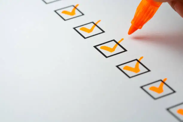Photo of Orange marking on checklist box with pen, Checklist concept