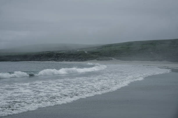 Fog hovers over the water and over the beach on St Ninian's Isle, Shetlands, Scotland.