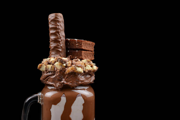 Chocolate extreme milkshake with brownie cake, chocolate paste and sweets. Crazy freakshake food trend. Copy space