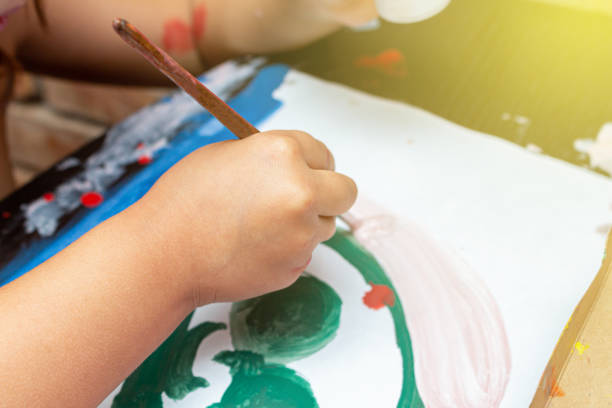 istock Small kid drawing with brush and paint. Childhood education concept. 1282490839