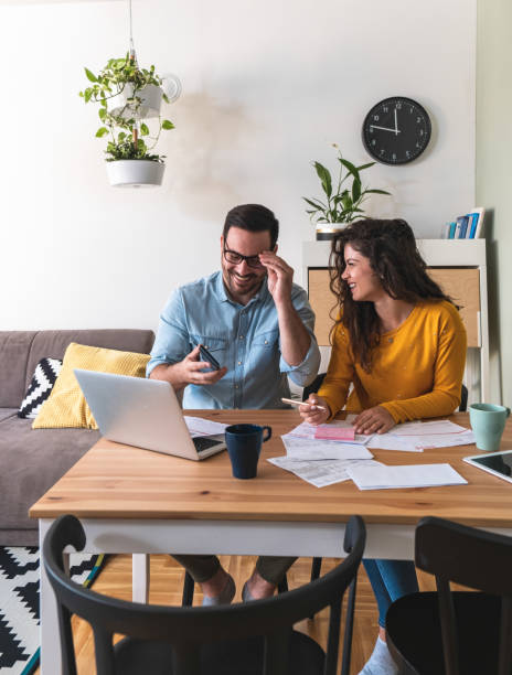 istock Smiling couple manage finances at home 1282491709