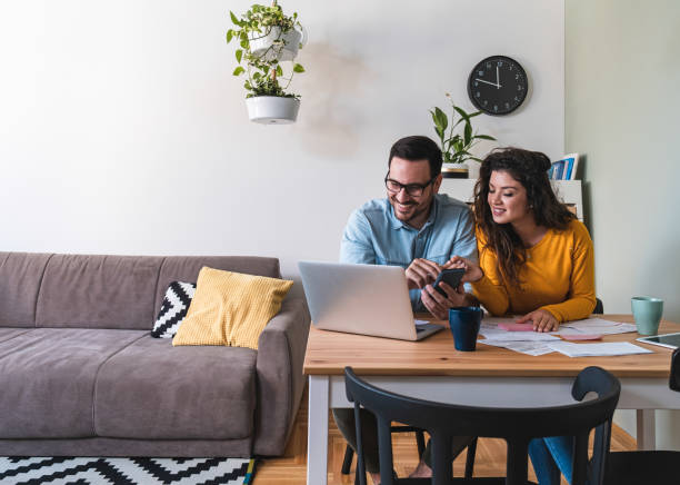 istock Smiling husband and wife paying bills online 1282491711