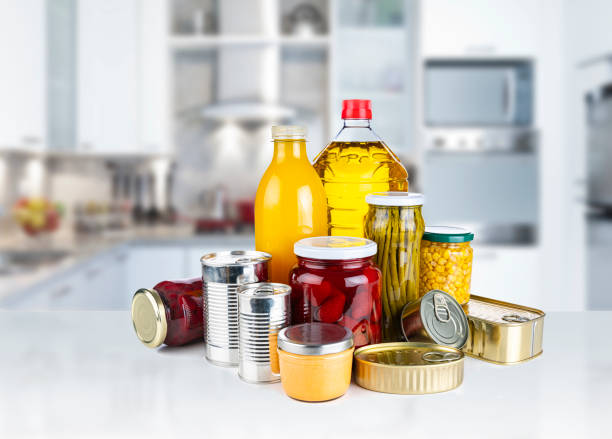 non-perishable food: canned goods, conserves, juice and oil on kitchen counter - non perishable imagens e fotografias de stock