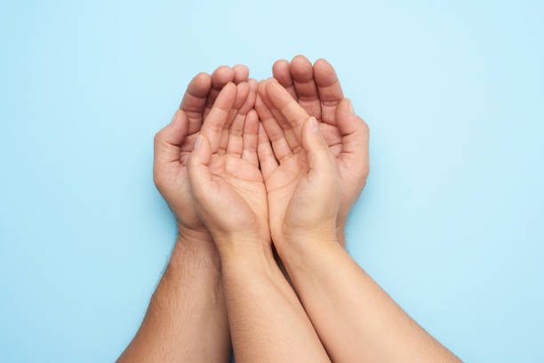 istock two female hands lie in male palms on a blue background 1282493321