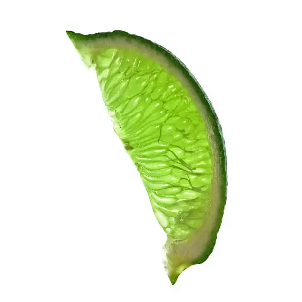 Single slice translucent lime wedge isolated on white background