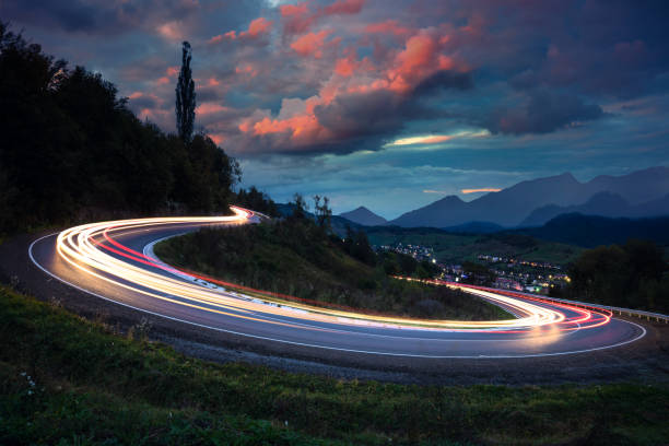 luces en el asfalto, por la noche en un camino de montaña - driving night car headlight fotografías e imágenes de stock