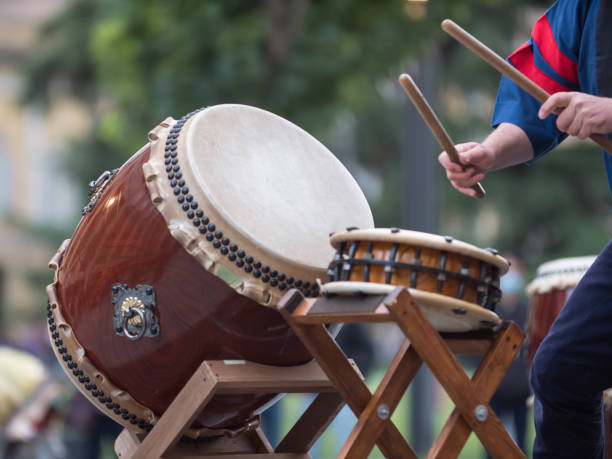 hombre tocando tambores de tradición musical japonesa durante un evento público al aire libre - taiko drum fotografías e imágenes de stock