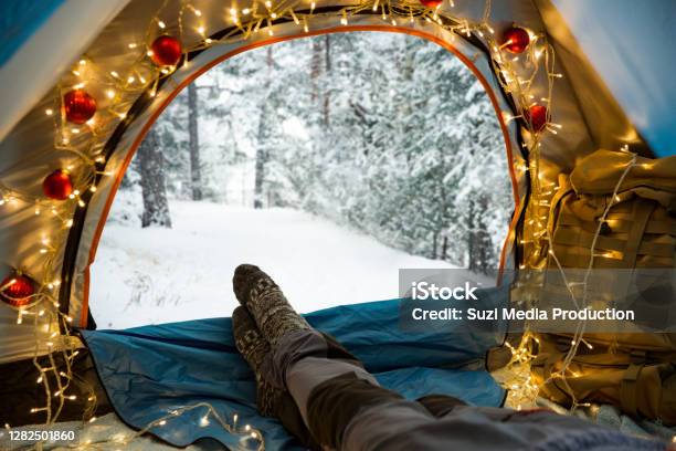 A Man Lying In A Tent Decorated With Christmas Lights Stock Photo - Download Image Now