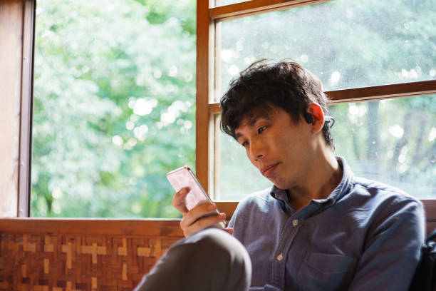 istock Asian man looking at his smartphone while relaxing in a Japanese house 1282503273