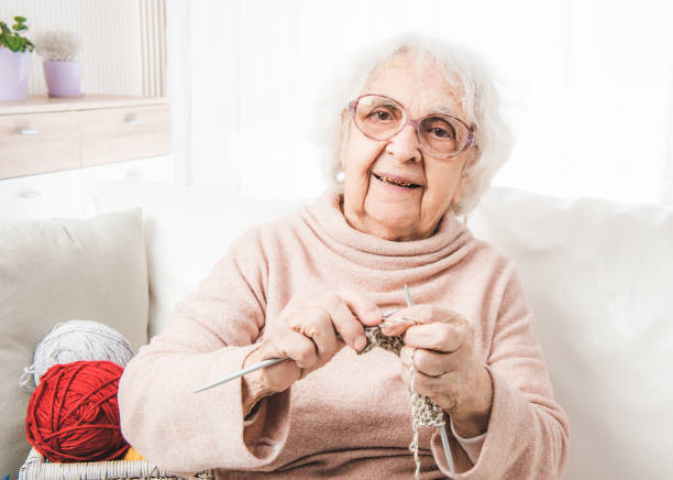 улыбаясь стариная женщина вязание - grandmother knitting senior women senior adult стоковые фото и изображения