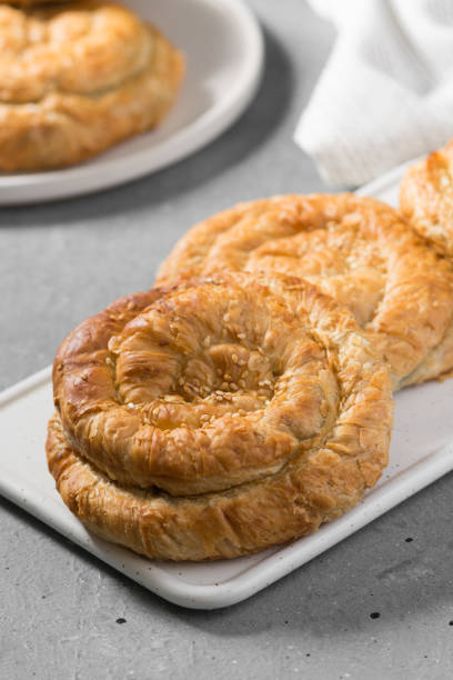 istock Buns on a white ceramic Board on a light gray table. Hearty pastries 1282505825