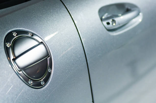 close up detail of a shiny chrome car fuel cap and door handle in the background - car car door green part of imagens e fotografias de stock