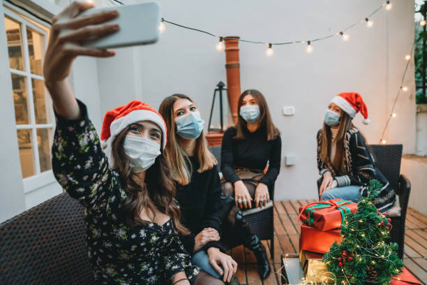 istock Four friends celebrating Christmas together, taking a selfie 1282509578