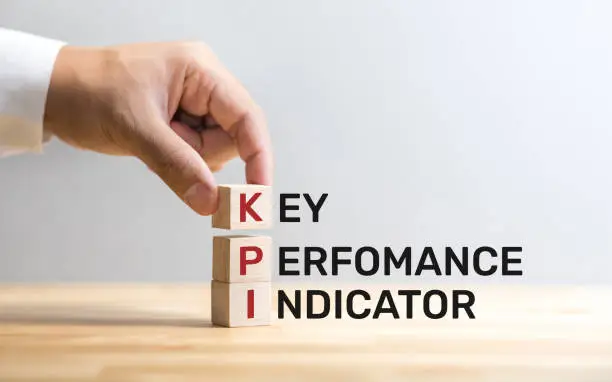Photo of KPI text on wood box with male hand.business analysis