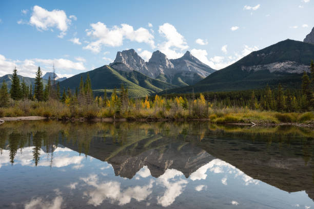 istock Scenery of Three Sisters Mountains reflection on Bow River in autumn forest 1282510254