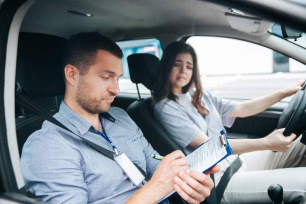 istock Upset woman failed driving exam bites lips and worries about it. Male instructor notice results of test in his paper. Female student holding wheel and looking troubled at the driving instructor. 1282510849