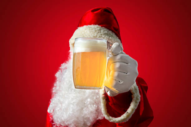 Santa Claus with a mug of beer. Coloured background and seletive focus Santa Claus with a mug of beer. Coloured background and seletive focus. alcoholics anonymous photos stock pictures, royalty-free photos & images