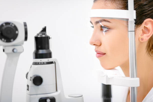 pacjentka pochylona twarzą na przyrząd optyczny do badania oczu - beautiful contemporary close up brown eyes zdjęcia i obrazy z banku zdjęć