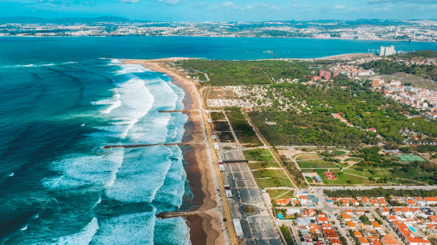 le riprese aeree della costa della costa da caparica di gloriose spiagge sabbiose, potenti onde atlantiche. portogallo - sea defence concrete foto e immagini stock