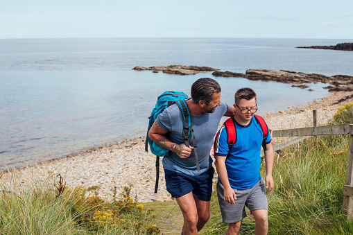 A father and his son with down syndrome on a staycation from from enjoying a walk on the Northumberland coast.