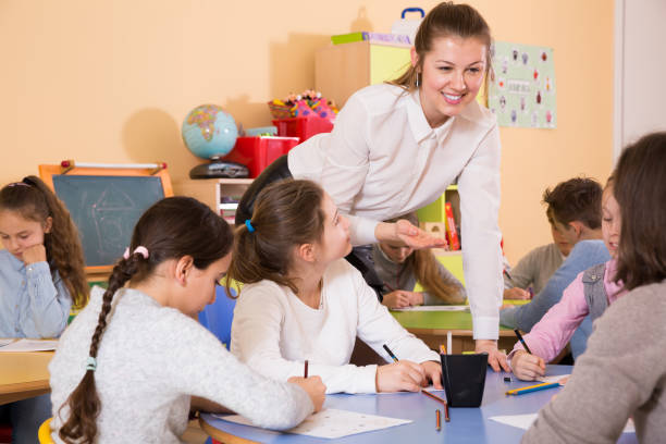 istock Teacher helping to elementary age children at drawing lesson 1282518234