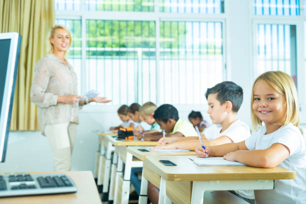 istock Side view of schoolkids group working on lecture in classroom 1282518291