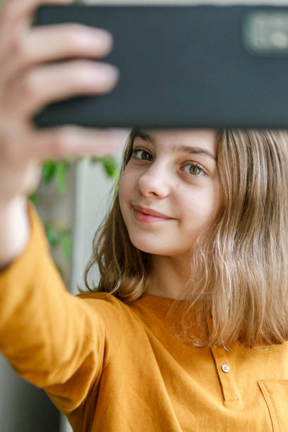 istock young girl at home taking selfie with mobile phone. Z generation concept using technology 1282518324