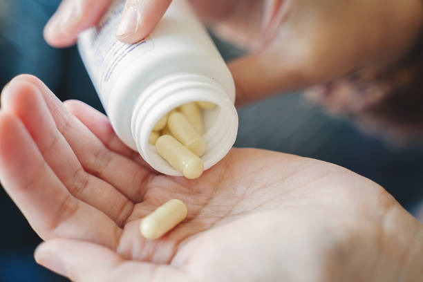 istock Taking medicines with glass of water 1282518651