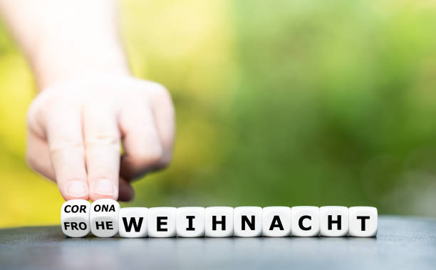 istock Symbol for a corona influenced Christmas. Hand turns dice and changes the German expression 