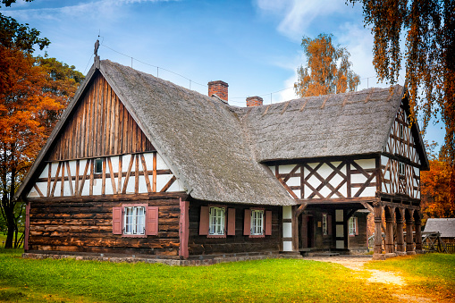 Olsztynek, Poland - August 31,2019:Early 20th century farmhouse with arcade extension, partly half timbered wall and thatched roof, Warmian-Masurian Voivodeship, Poland