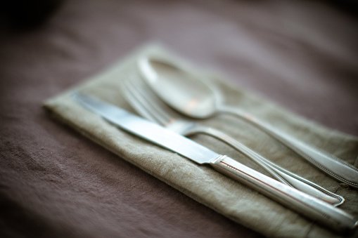 Silverware on a table dress with natural fiber tablecloth.