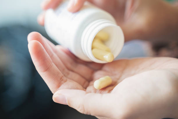 istock Taking medicines with glass of water 1282522839