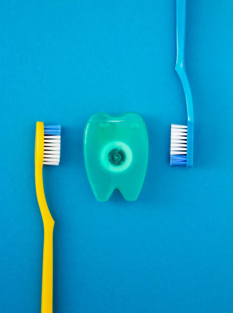 istock Toothbrushes and dental floss on blue background. 1282525678