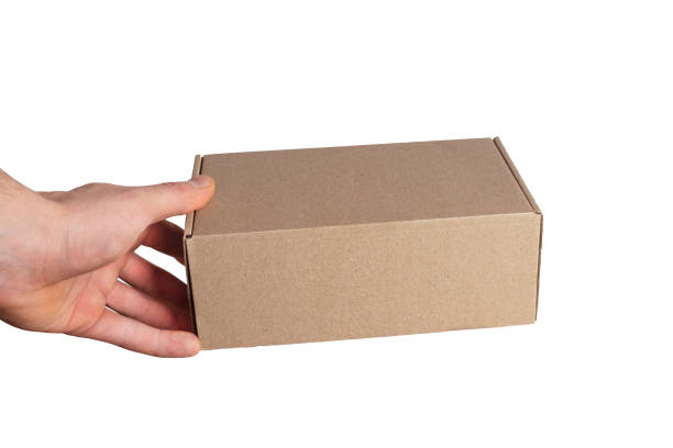 Box in hand. Holding cardboard box in mens hand. Isolated on white.