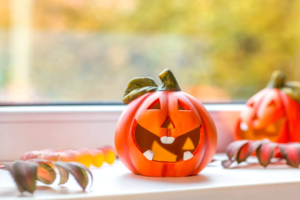istock Funny decorative pumpkins for Halloween stand on the windowsill. 1282526311