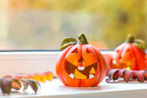 istock Funny decorative pumpkins for Halloween stand on the windowsill. 1282526347