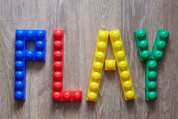 The word Play laid out from large pieces of constructor on a wooden background.