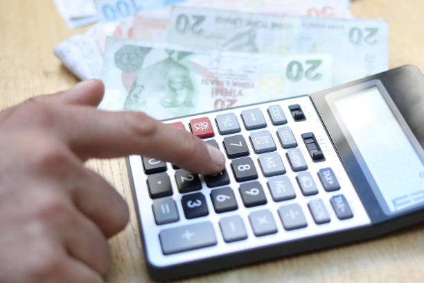 istock man doing financial transactions with calculator holding money 1282529361