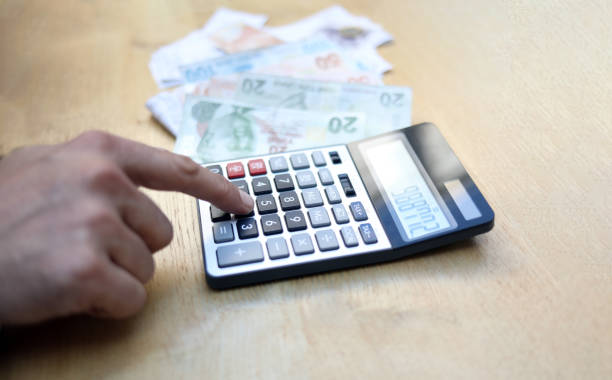 istock man doing financial transactions with calculator holding money 1282529443