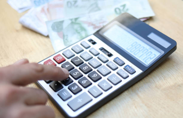 istock man doing financial transactions with calculator holding money 1282530395