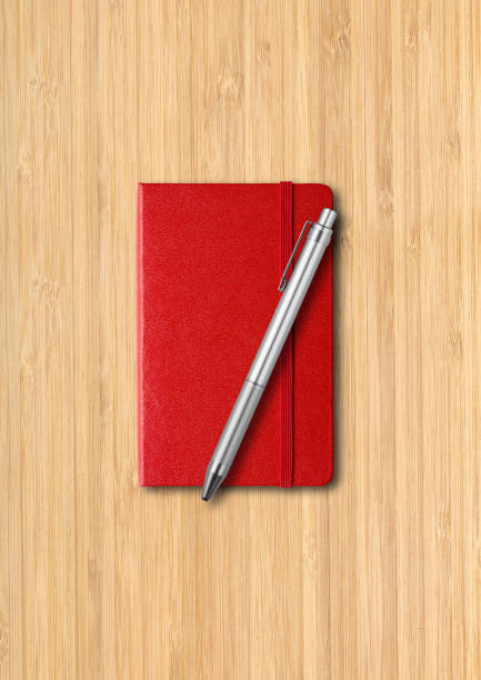 istock Red closed notebook with a pen on wooden background 1282530493