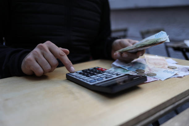 istock man doing financial transactions with calculator holding money 1282530727