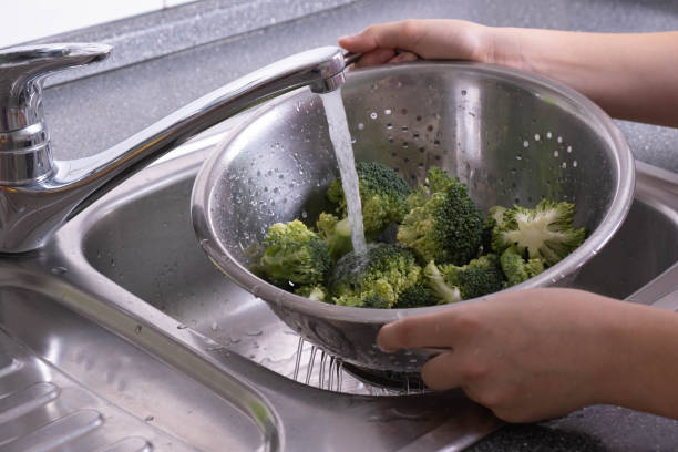 istock colander in hand, and there is broccoli in it, it is washed under running water 1282531112