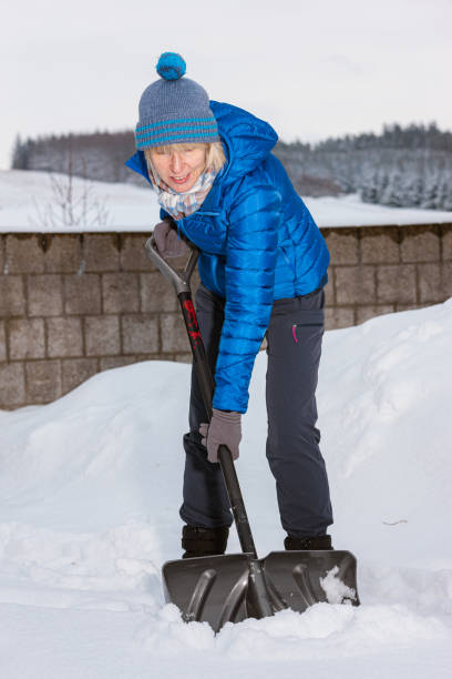 istock Senior woman with snow shovel 1282531795