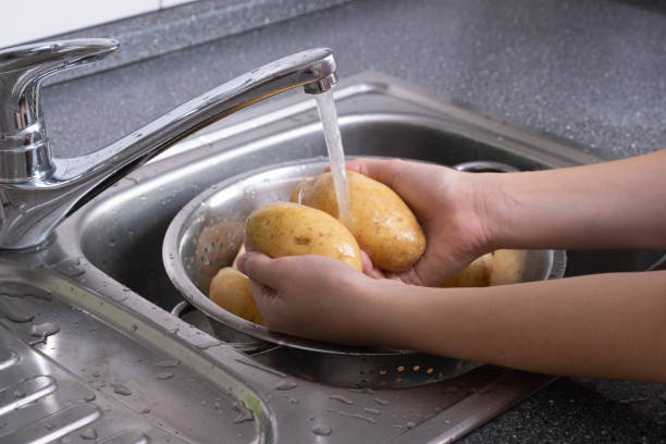 istock potatoes are washed under running waste water in the kitchen for cooking 1282532257