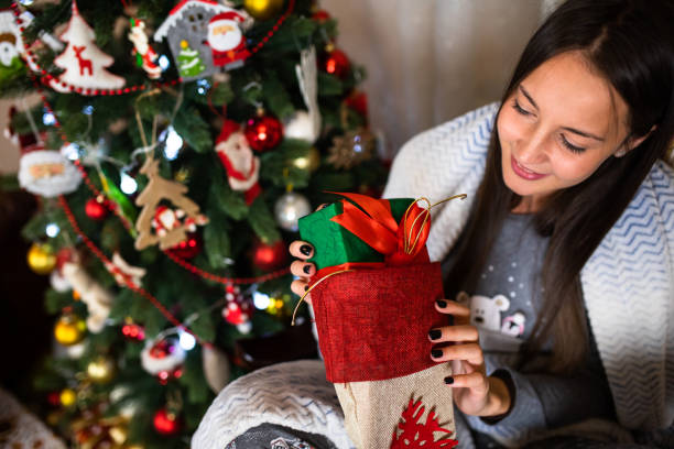 istock A pretty woman pulling a present out of a Christmas stocking 1282532497