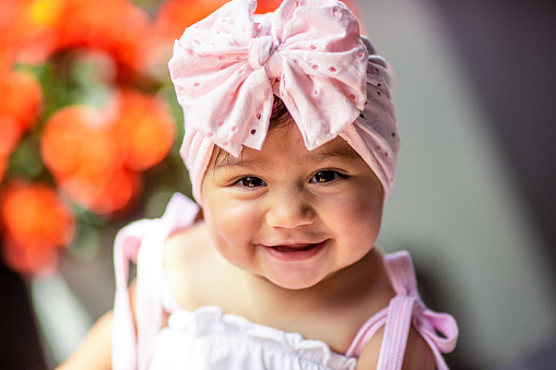 Portrait of a cute baby girl laughing while getting her picture taken.