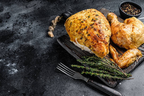 istock Butchered  grilled whole chicken.  Black background. Top view. Copy space 1282533224